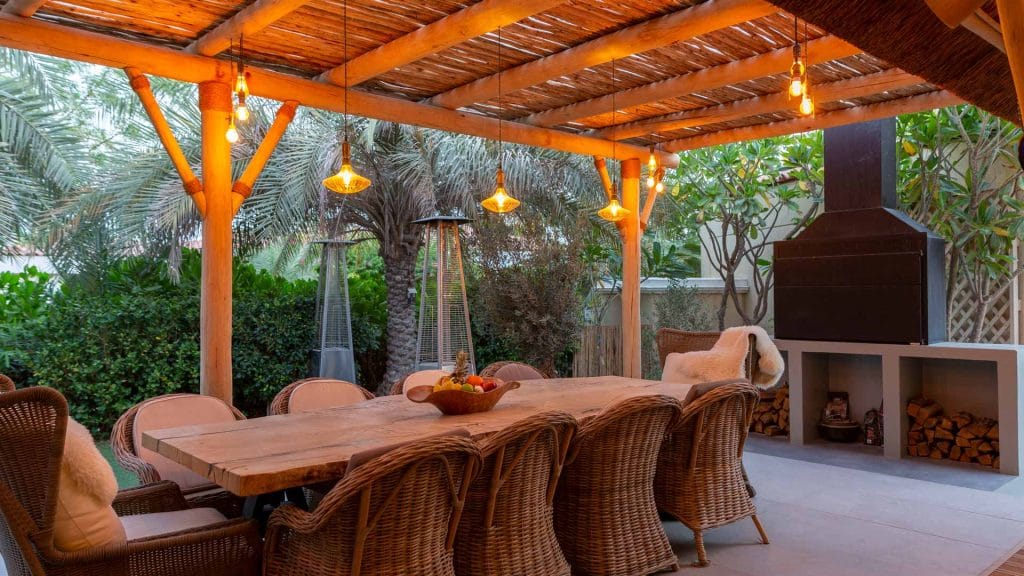 An exclusive outdoor living space with timber pergola and thatched roof structure.