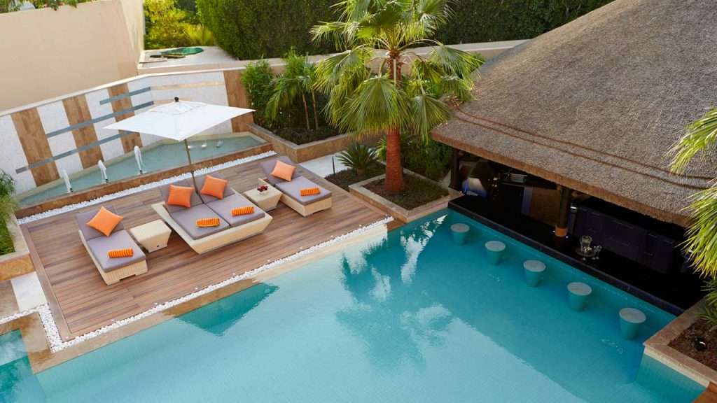 Sunken thatched gazebo with swim-up pool bar and decking.