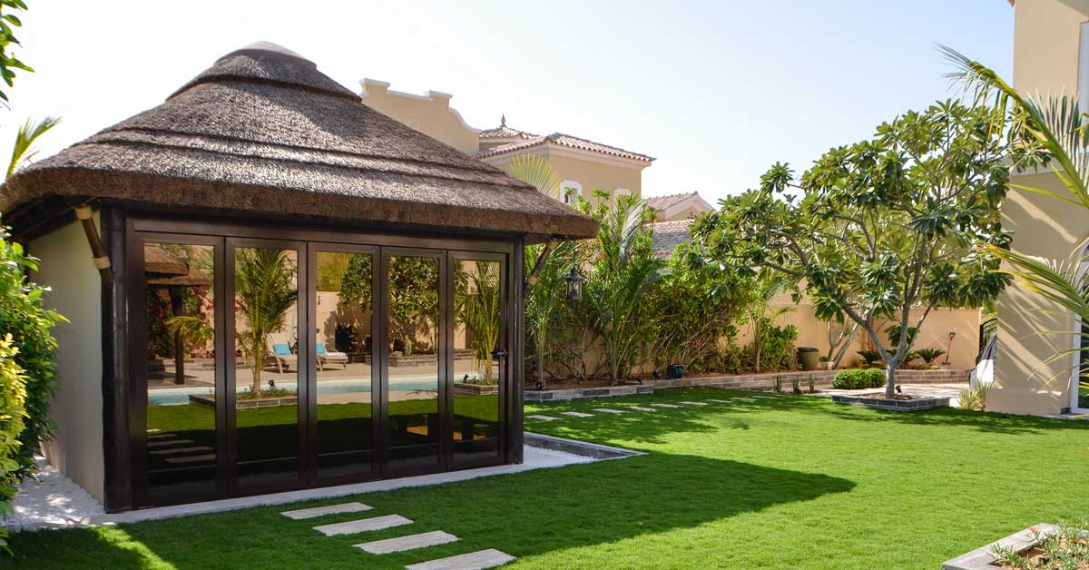 Glass and drywall combination with thatched roof