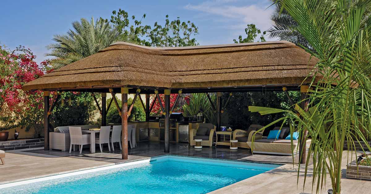 Thatched gazebo with dining area overlooking the swimming pool