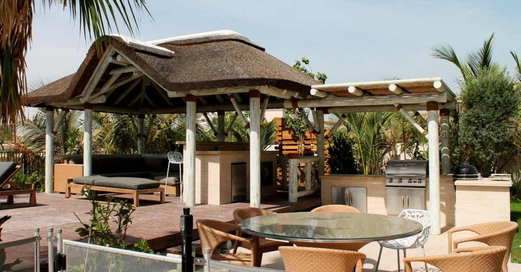 White washed thatched gazebo with outdoor kitchen, pergola and seating area in Arabian Ranches, Dubai