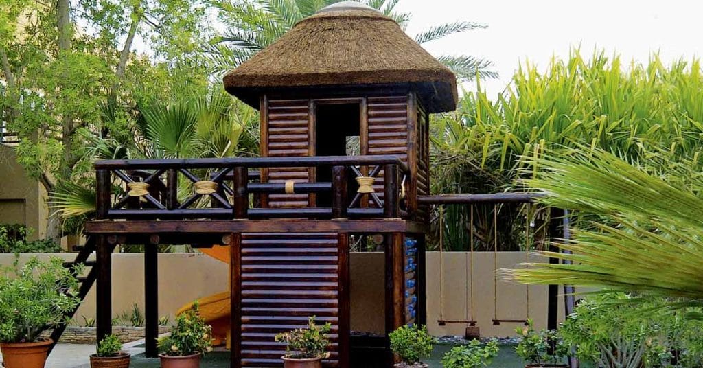 Eco-friendly playstructure timber climbing structure with thatched roof, swings and climbing wall
