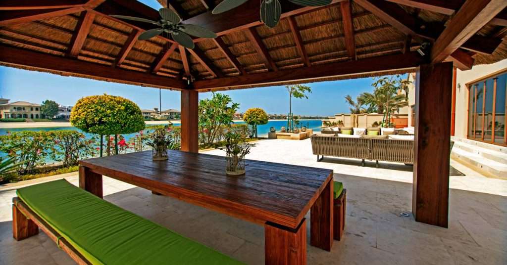 Outdoor seating area on the Palm Jumeirah under a thatched roof gazebo