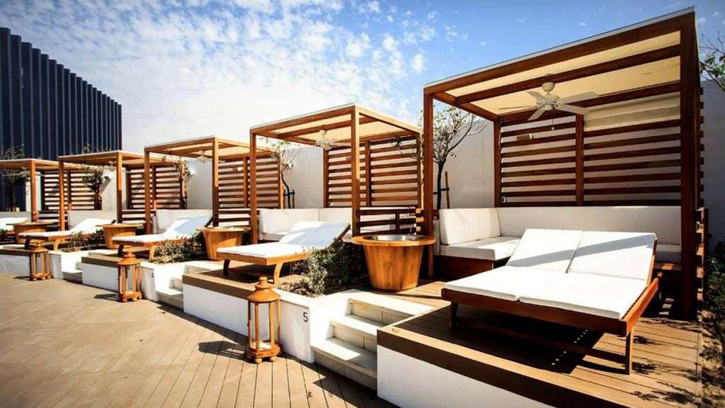 Cape Reed timber daybeds at Nikki Beach Dubai, providing luxurious relaxation by the poolside.