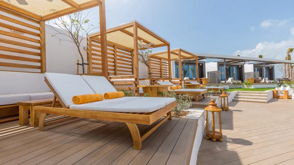 Cape Reed timber daybeds at Nikki Beach Dubai, providing luxurious relaxation by the poolside.