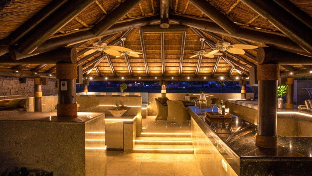 Thatched outdoor entertainment area with BBQ kitchen area and swim-up poolbar
