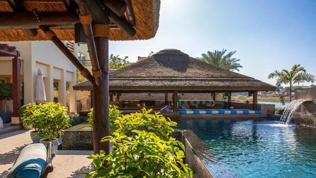 Thatched outdoor entertainment area with swim-up poolbar