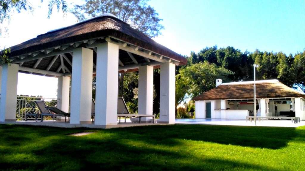 Thatched poolside structures on concrete columns