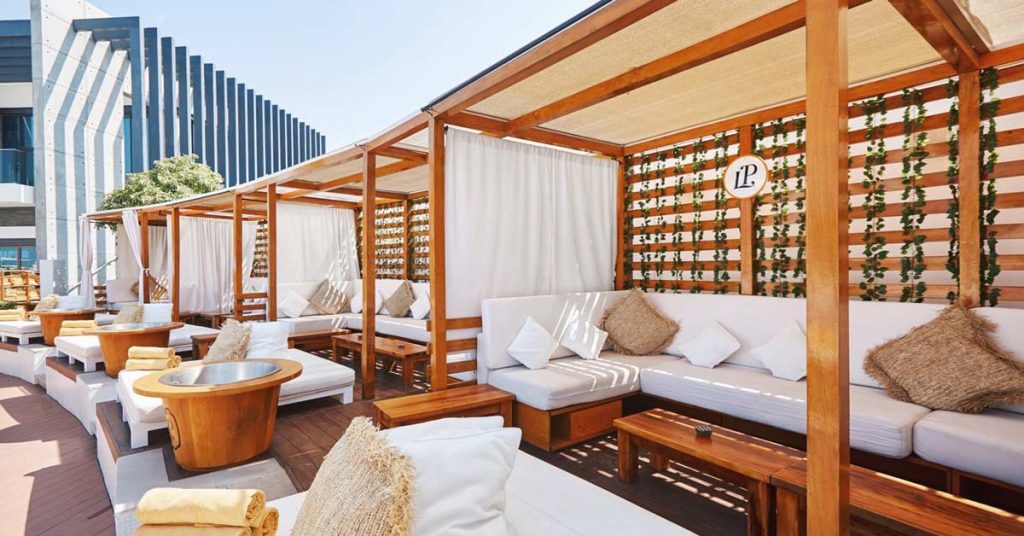 Cape Reed timber daybeds at Nikki Beach Dubai, providing luxurious relaxation by the poolside.