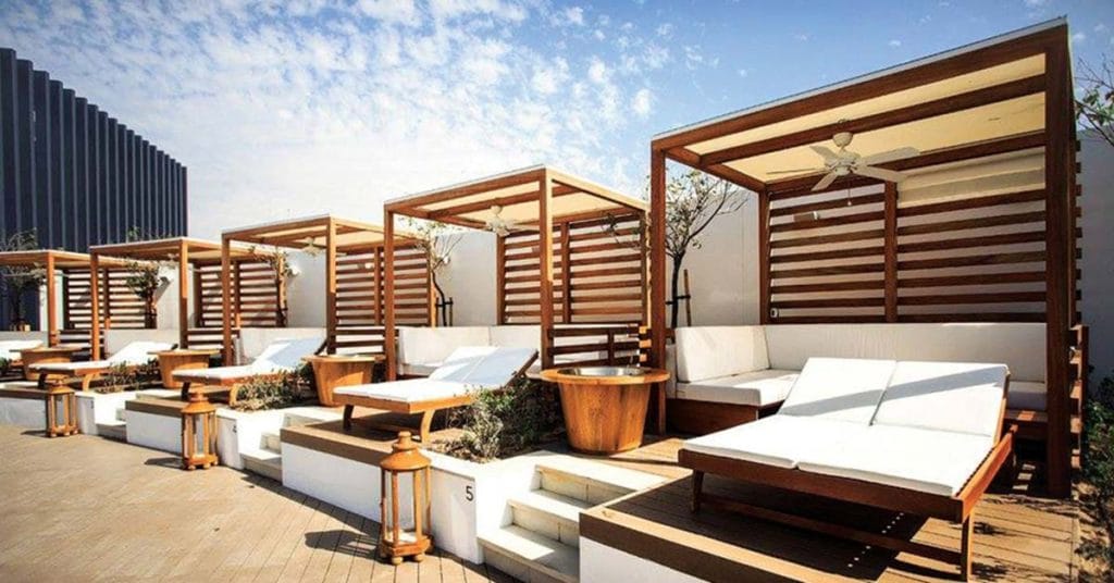 Cape Reed timber daybeds at Nikki Beach Dubai, providing luxurious relaxation by the poolside.