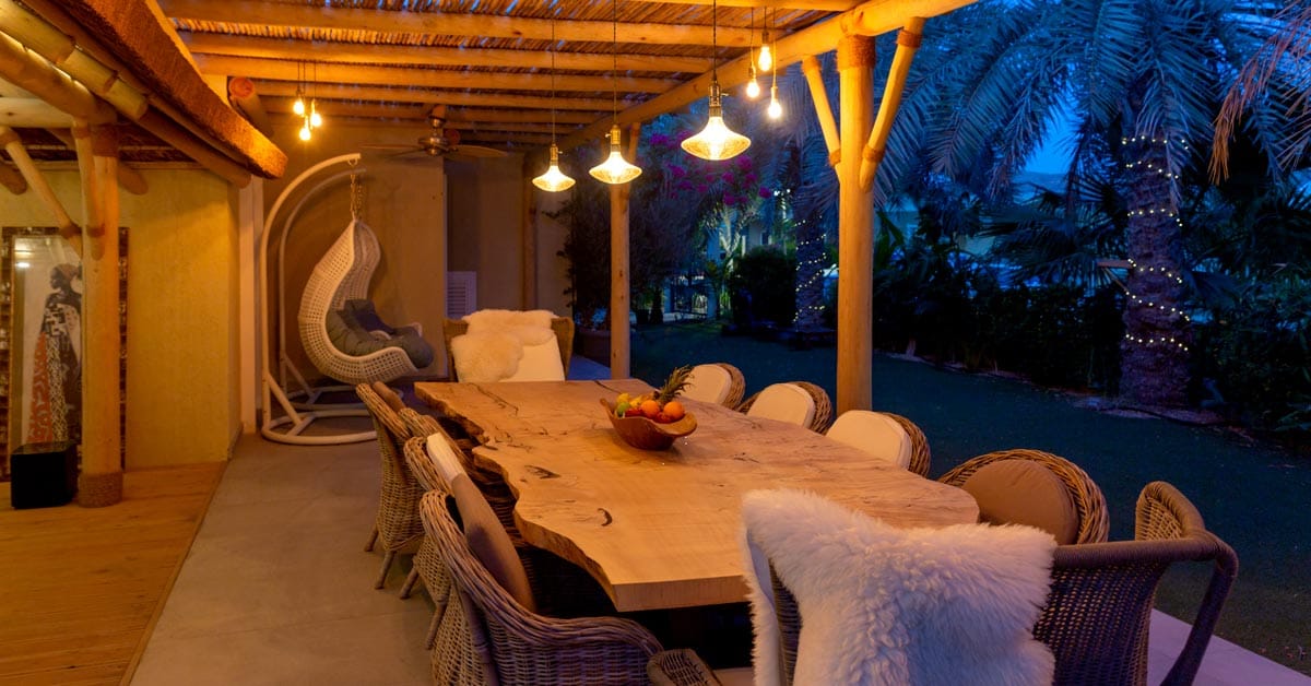 Serene outdoor dining space beneath a rustic cape reed pergola.
