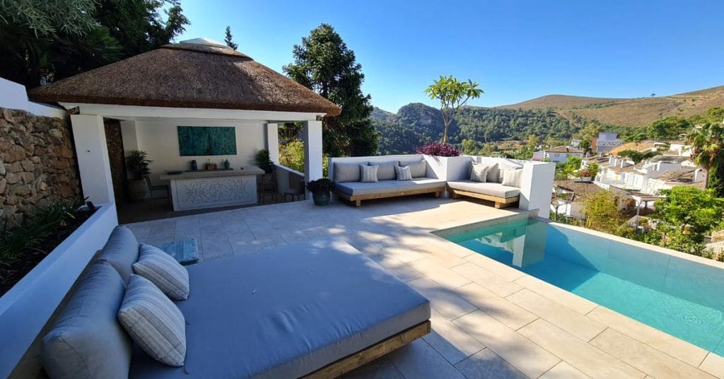 Poolside thatched roof structure with laminated timber beams.