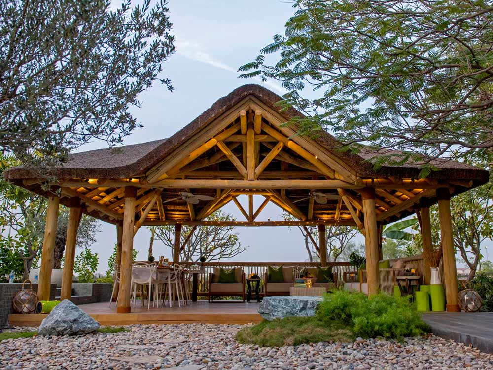 Elevate your outdoor space with our Ibiza thatched roof and timber structure with a gabled entrance.