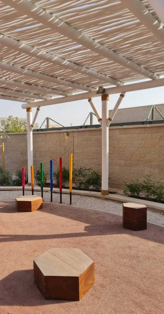 Recreational timber playground with interactive learning spaces at Misk School, Saudi Arabia.