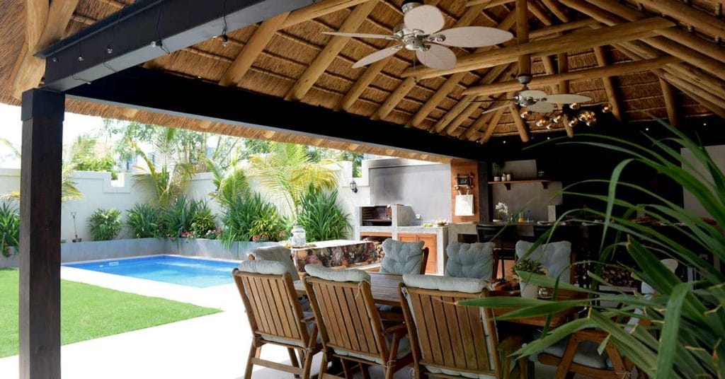 A cozy and stylish thatched outdoor living room perfect for relaxation and entertaining guests.