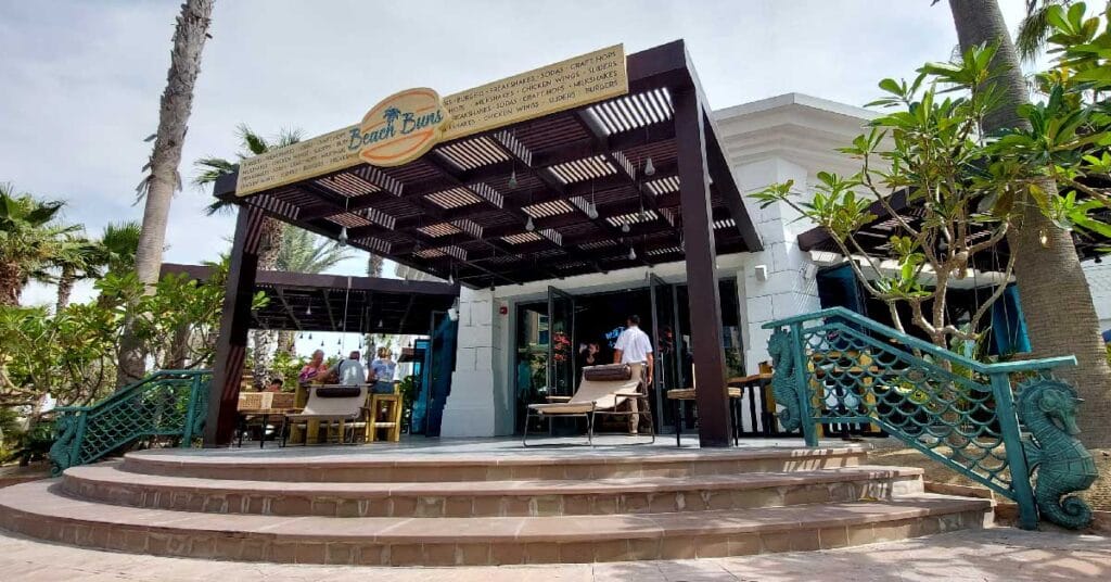 Beach Buns restaurant with square timber pergolas by Cape Reed, providing shaded seating for guests enjoying gourmet burgers and ocean views.