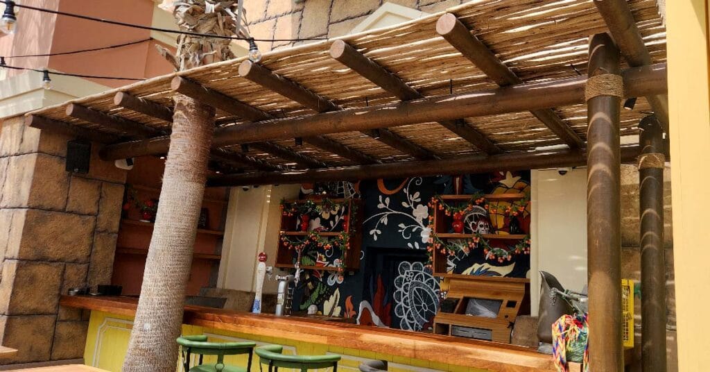 En Fuego’s lively terrace featuring a rustic Cape Reed timber pergola, creating a semi-shaded space perfect for outdoor dining.