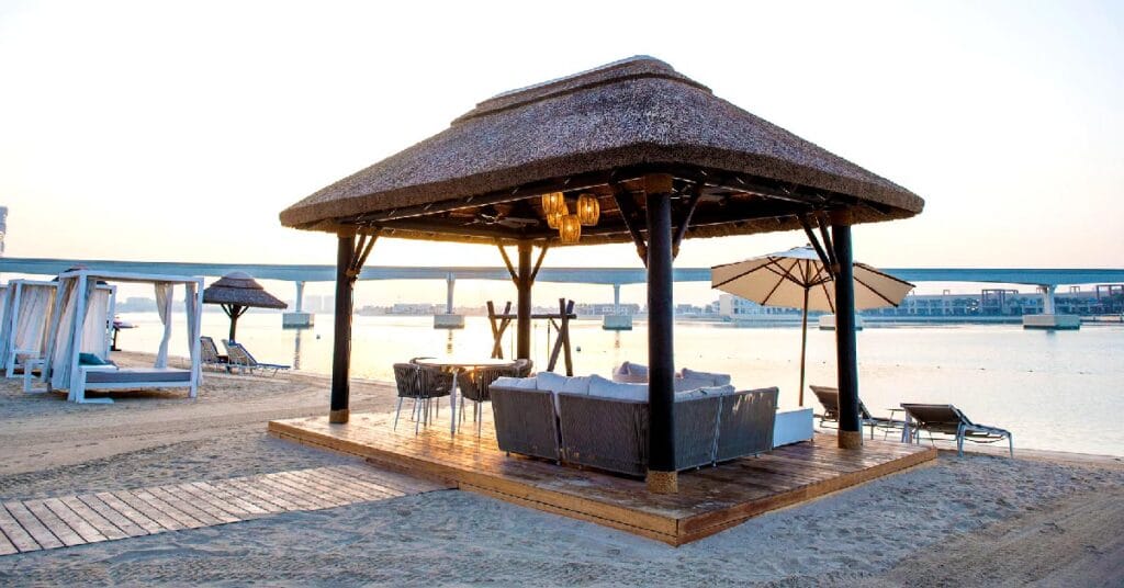 Romantic thatched gazebo with a decked walkway leading from the beach, featuring swinging timber daybeds for couples to relax and enjoy stunning Gulf views.