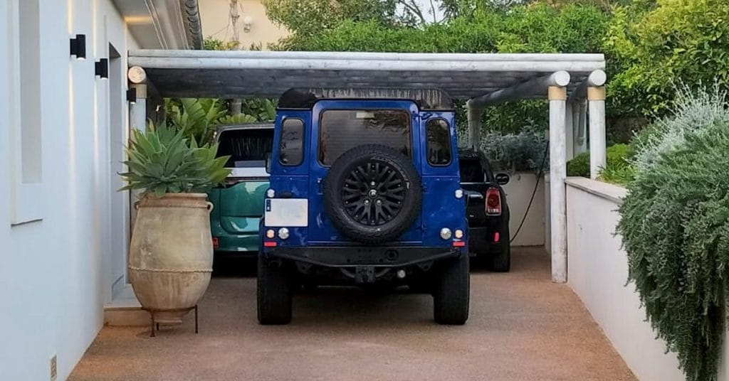 Timber pergola carport shading luxury vehicles in the UAE.