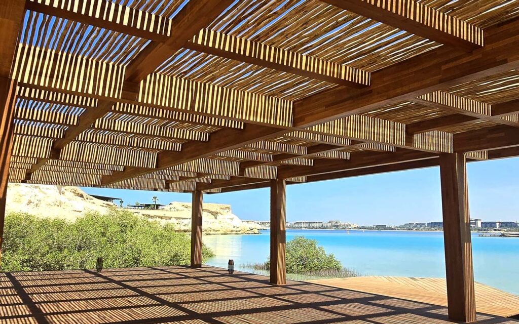 Timber pergola shading a beachfront deck at Six Senses AMAALA with sea views