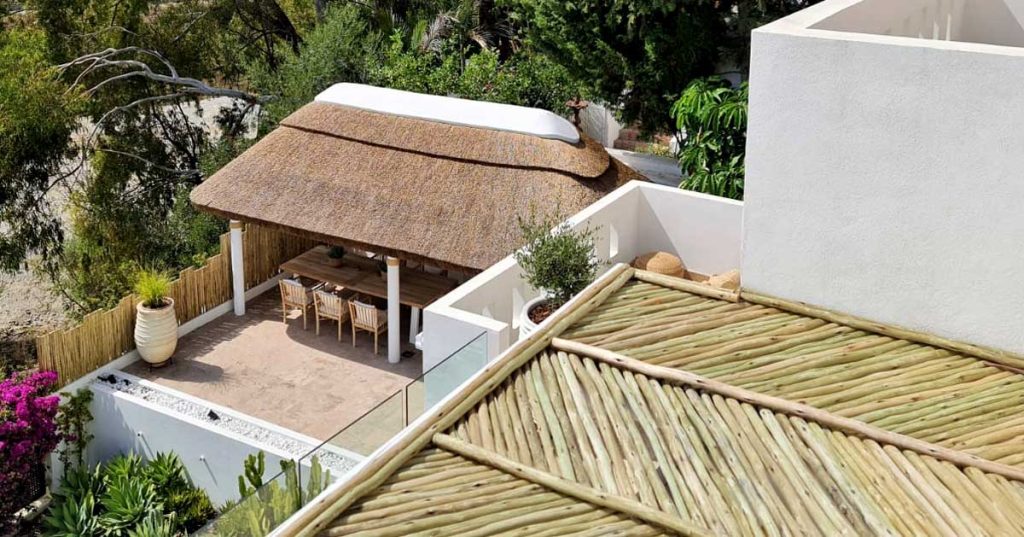 thatched-outdoor-seating-area-with-lath-fence-and-pergola