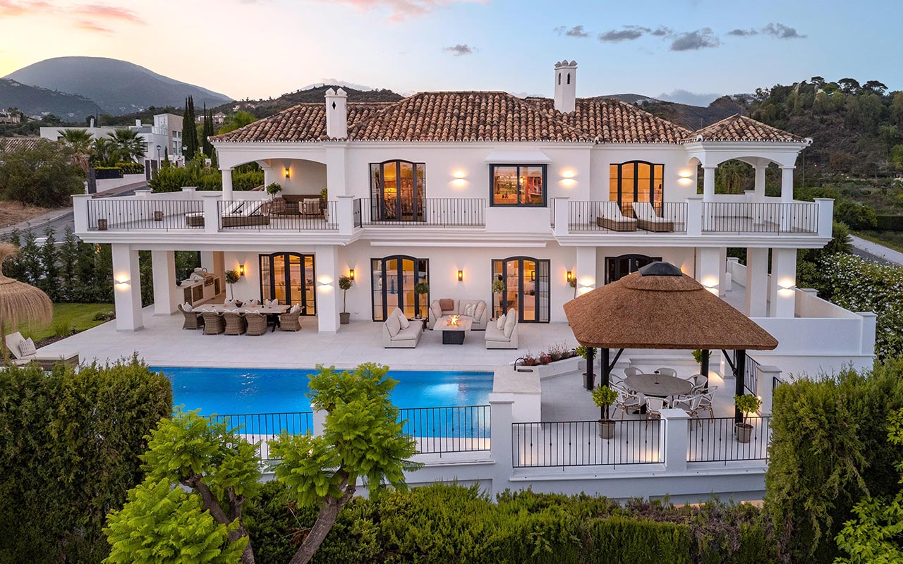Renovated white villa in Nueva Andalucía with pool and Cape Reed thatched gazebo at golden hour
