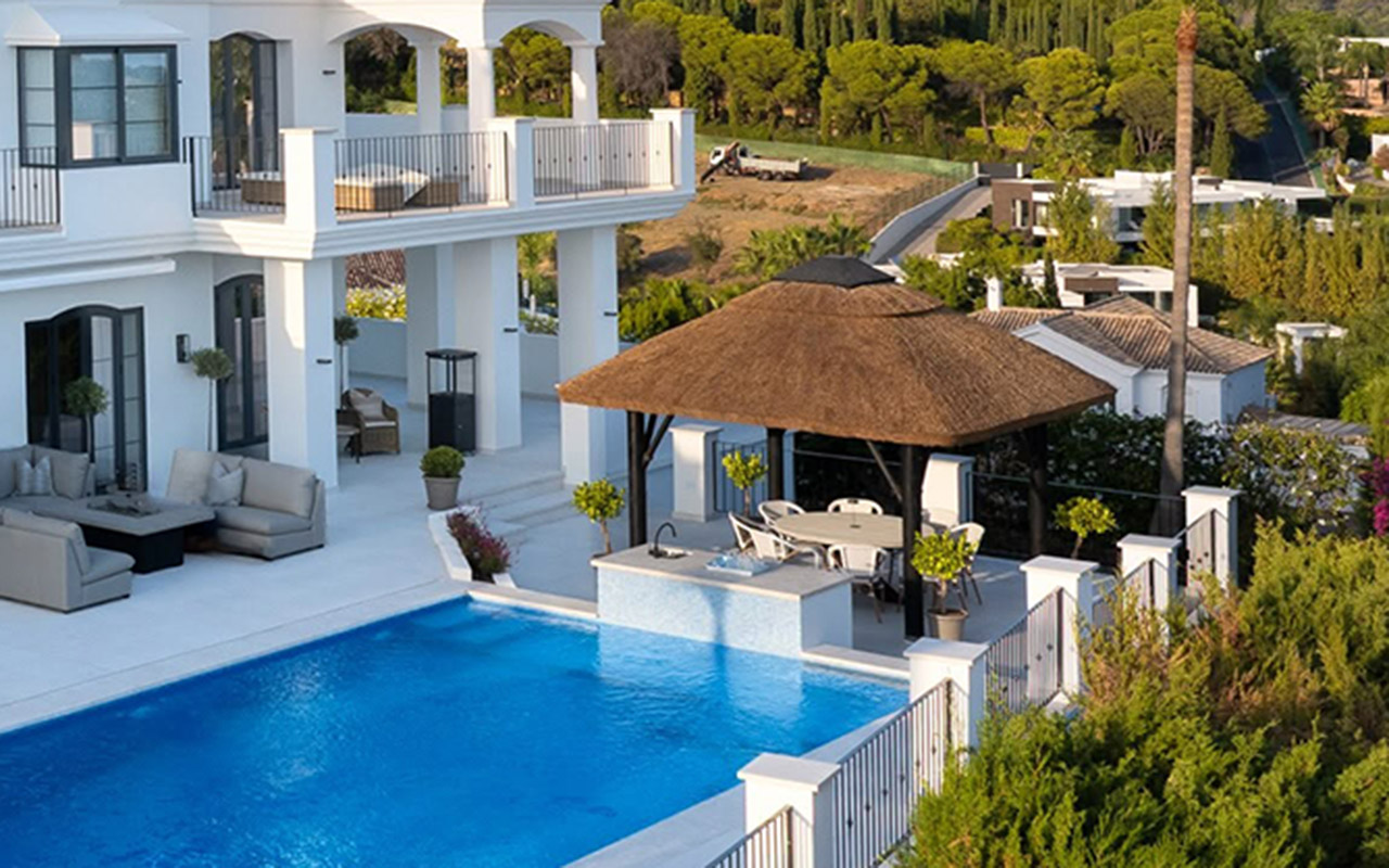 Poolside thatched gazebo and terraces of a luxury villa in Nueva Andalucía by Cape Reed International