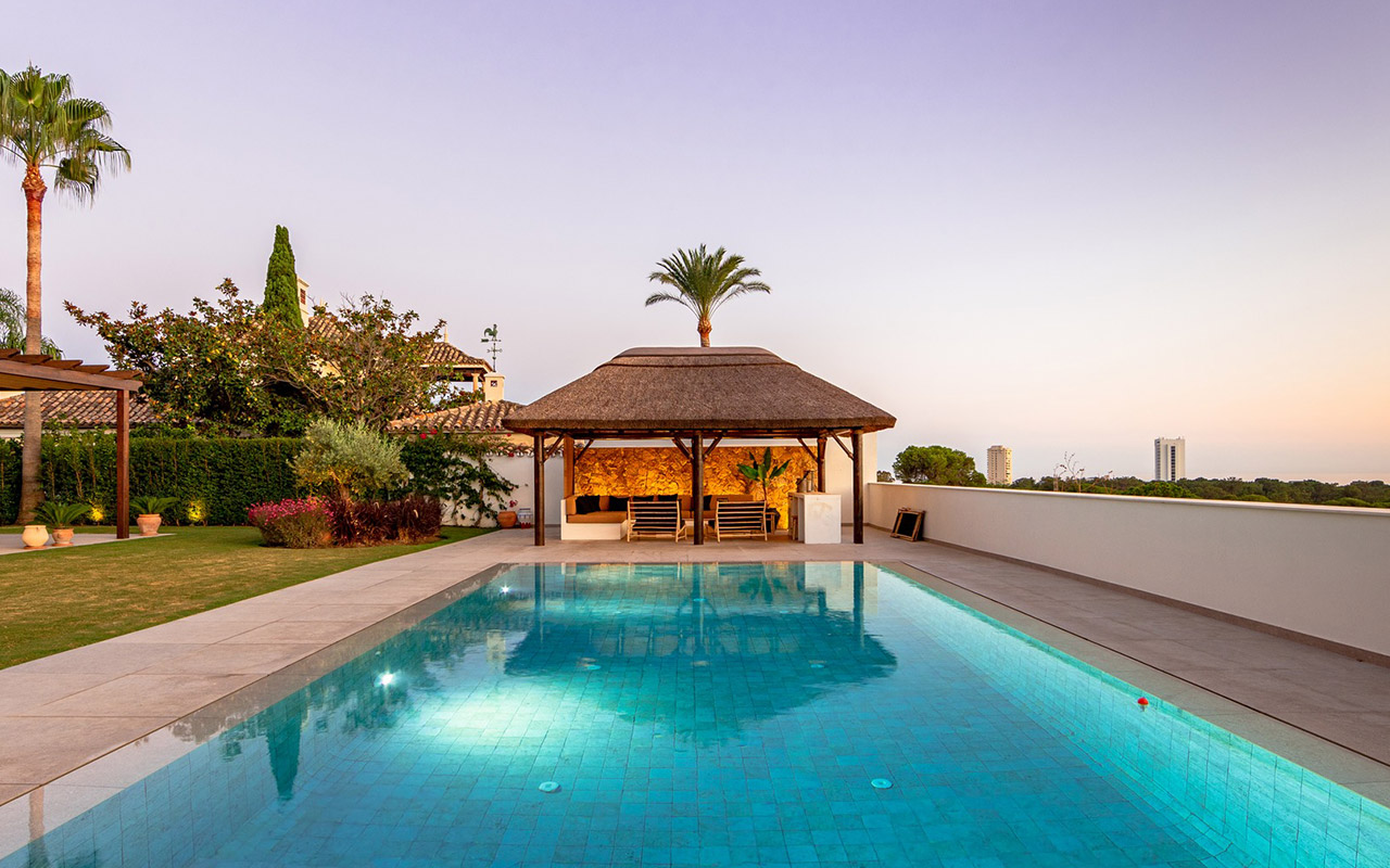 Gazebo de junco africano en la terraza junto a la piscina de una villa de lujo en Marbella, España